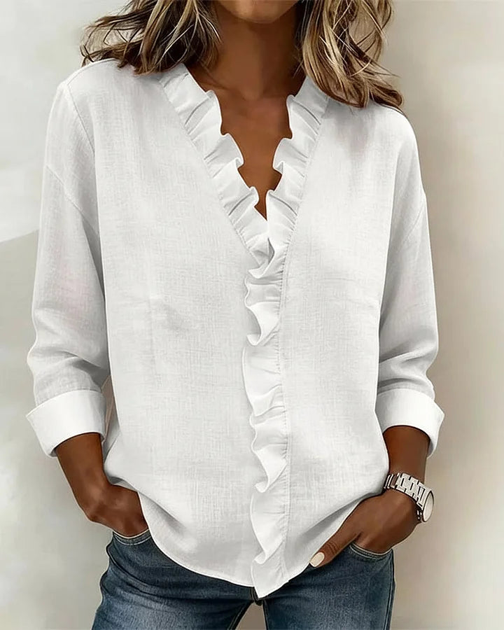Close-up of elegant women's ruffled V-neck blouse, showcasing intricate details & comfortable fabric.