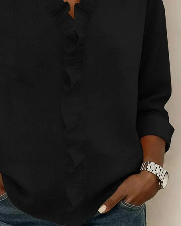 Textured close-up of soft fabric on women's ruffled V-neck long sleeve blouse, ensuring comfort & style.