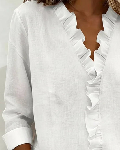 Detail of long sleeves and ruffled cuffs on elegant women's V-neck blouse, a versatile top for any season.