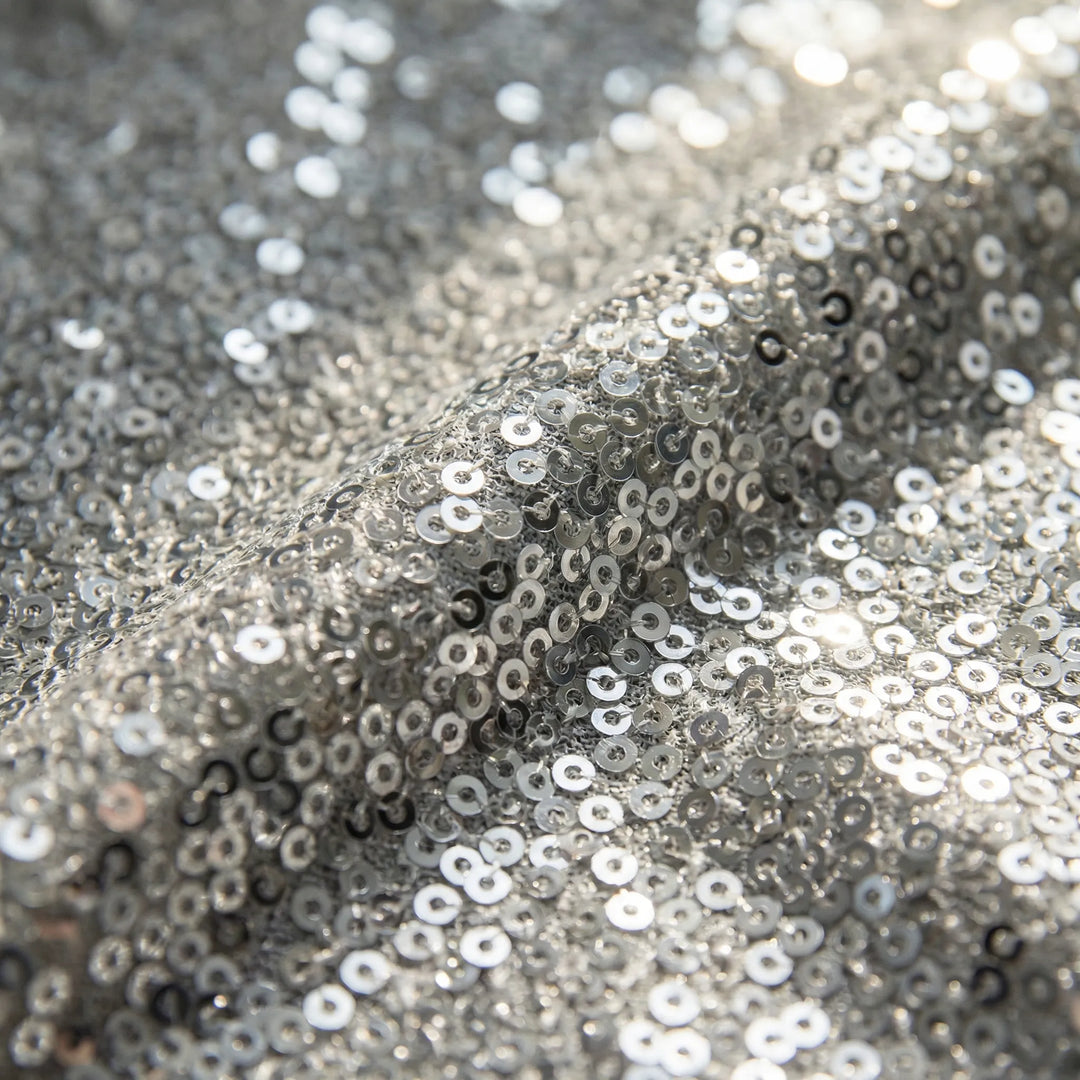 Close-up of a women's shimmer V-neck top with long sleeves, showcasing the fabric texture.