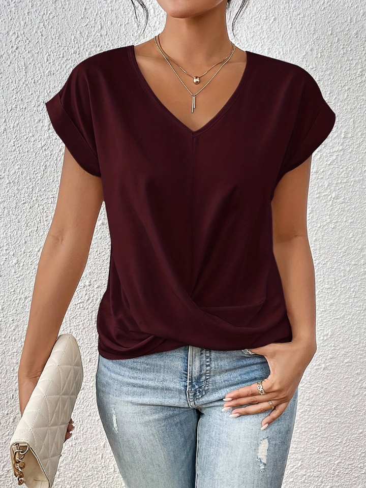 Chic women's short sleeve blouse. Silky fabric, elegant V-neck & unique twist-front detail for any occasion.