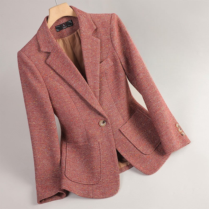 Close-up of women's elegant speckled tweed blazer. Detailed fabric, single button & tailored fit for chic style.