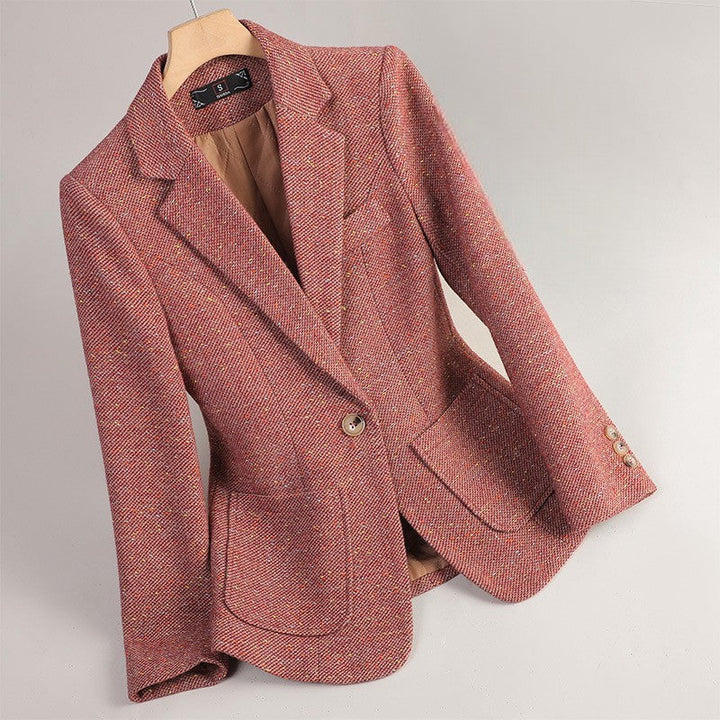 Close-up of women's elegant speckled tweed blazer. Detailed fabric, single button & tailored fit for chic style.