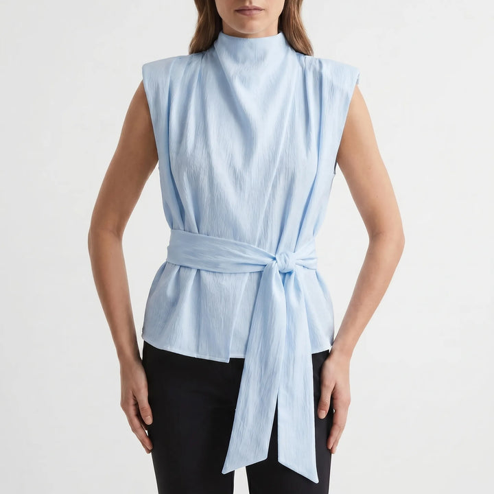 Fashionable women's elegant sleeveless blouse with an adjustable tie-waist and textured fabric for a flattering fit.