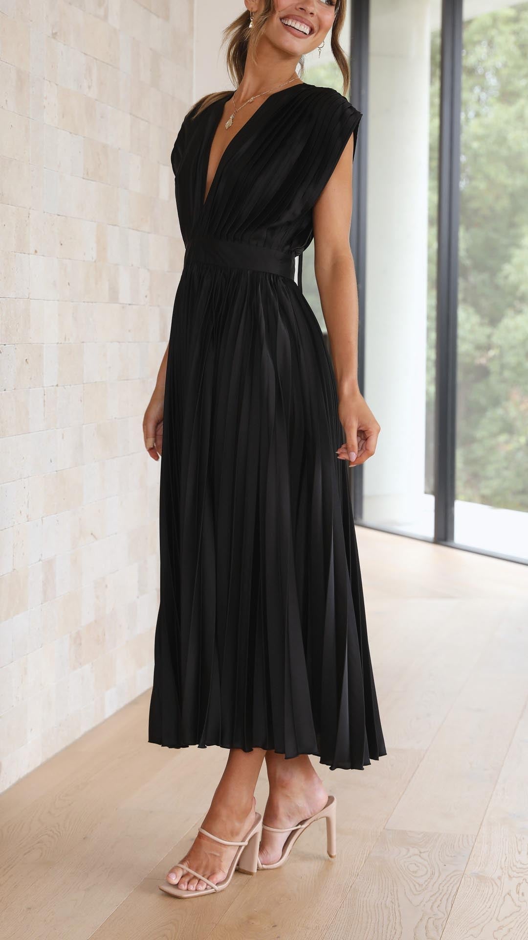 Women's sleeveless V-neck formal maxi dress with elegant pleats, ideal for a gala event.
