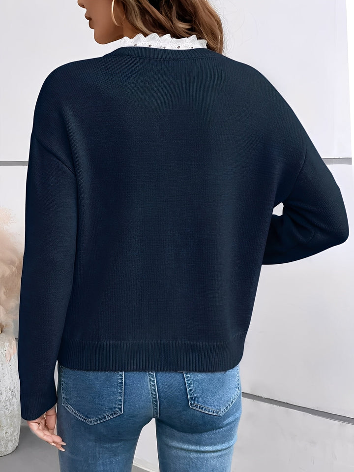 Close-up of intricate lace trim on the V-neckline of a fashionable women's long-sleeve pullover sweater.