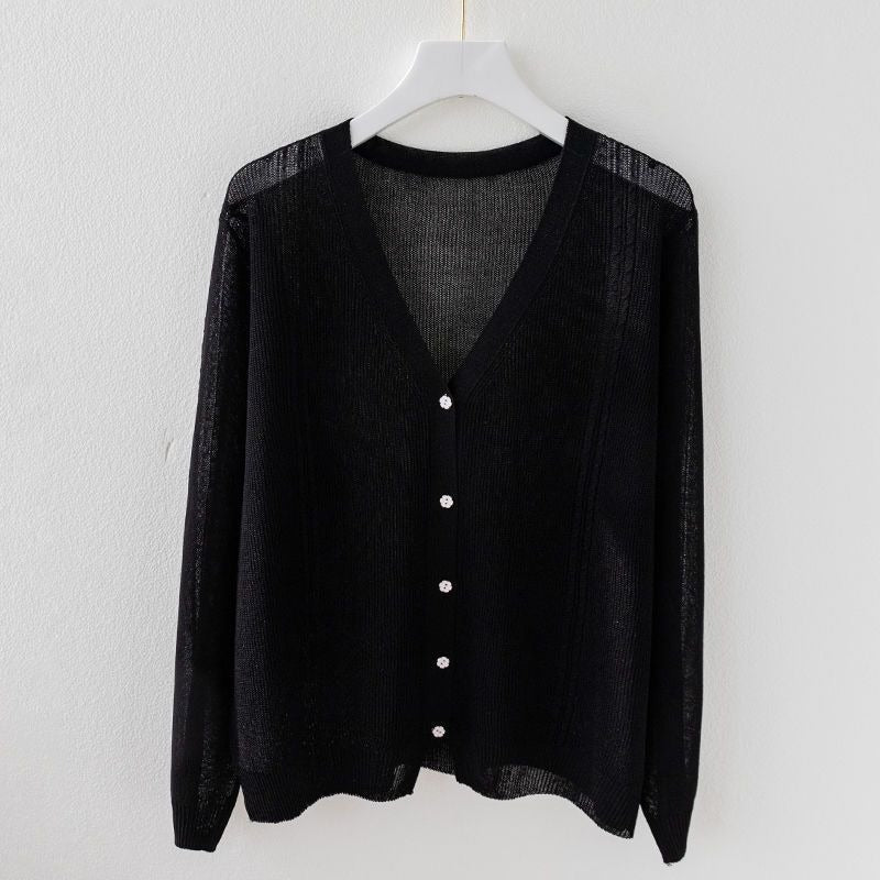 Close-up of elegant V-neck silk blend knit top. Detailed view of soft fabric and classic button-up design for women.