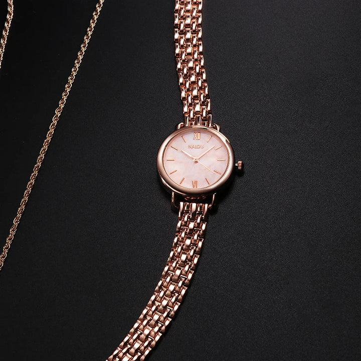 Women's wrist wearing an elegant rose gold watch with marble dial, fashion accessory.