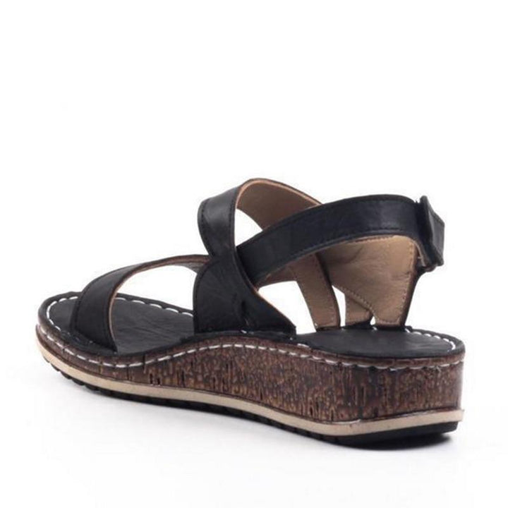 White elegant women's wedge sandals, offering comfort & style for summer footwear.