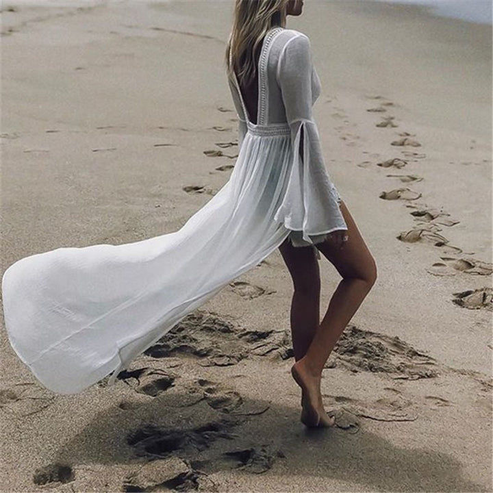 Women's elegant white maxi vacation dress with open back and flare sleeves, ideal for beach or resort.