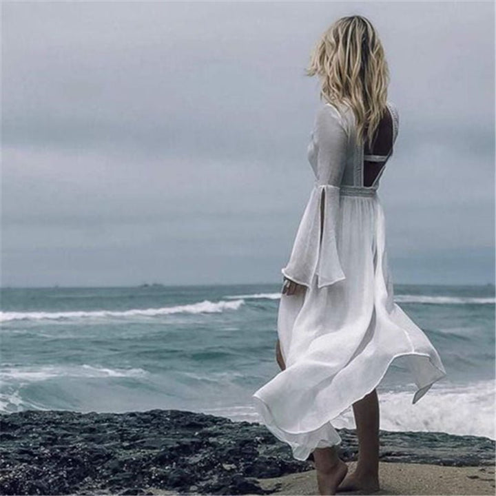 Women's bohemian white open back maxi beach dress, a flowy and elegant summer vacation outfit.