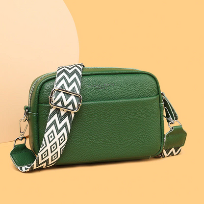 Close-up of the luxurious cowhide genuine leather texture on a women's fashion handbag.
