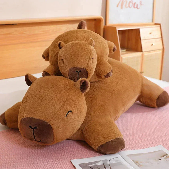 Kids hugging a giant capybara plushie, a comforting soft toy and snuggle buddy.