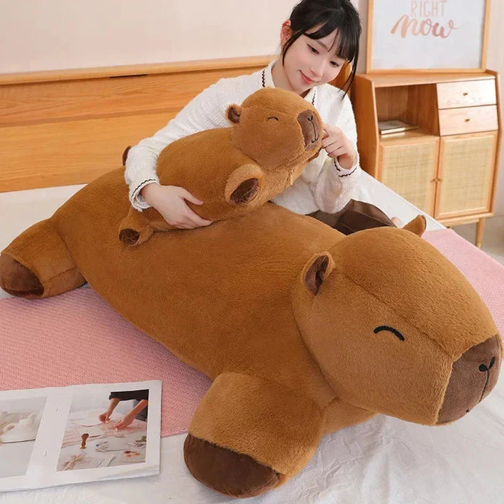 Giant capybara plush on bed, ready for cozy snuggles, a soft relaxation buddy.