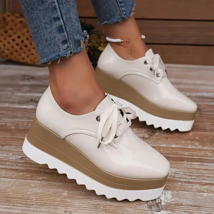 Side view of glossy white chunky platform sneakers for women, emphasizing comfort & fashion.