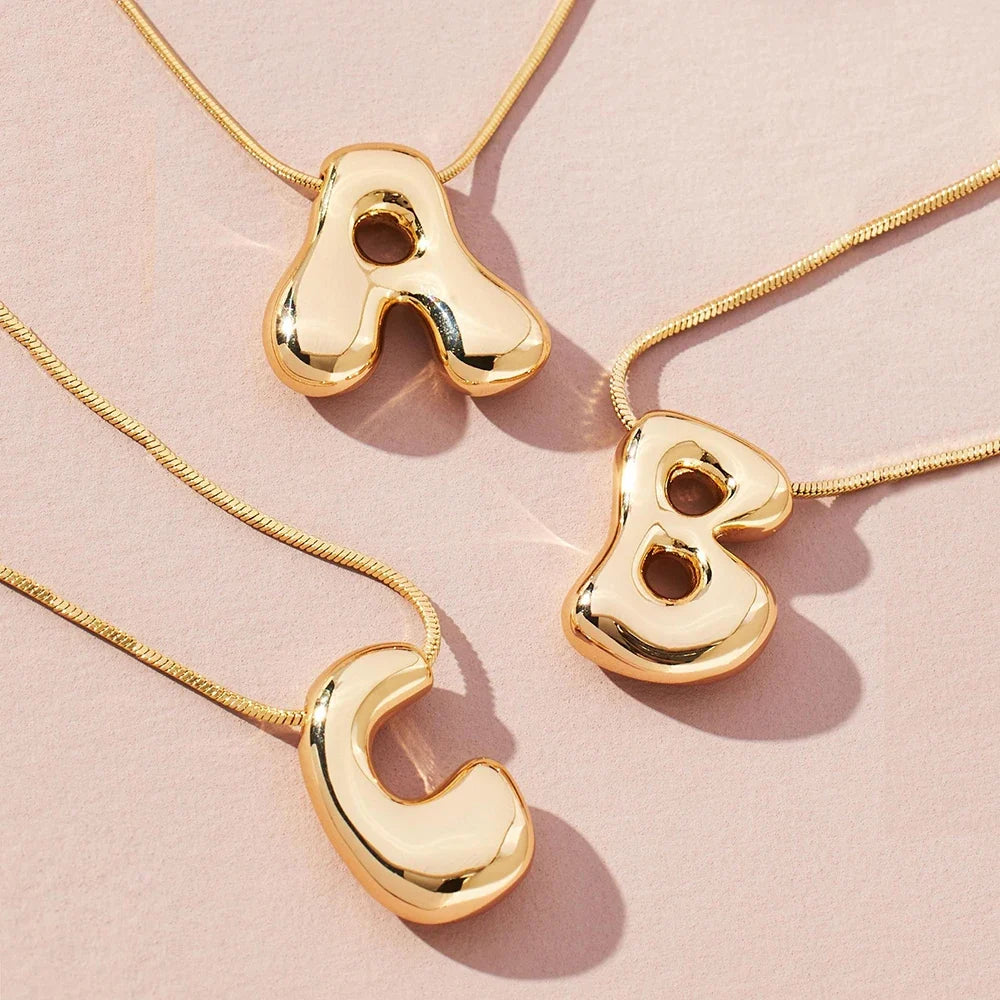 Personalized gold-tone initial necklace, chic letter pendant for women, a stylish statement accessory.