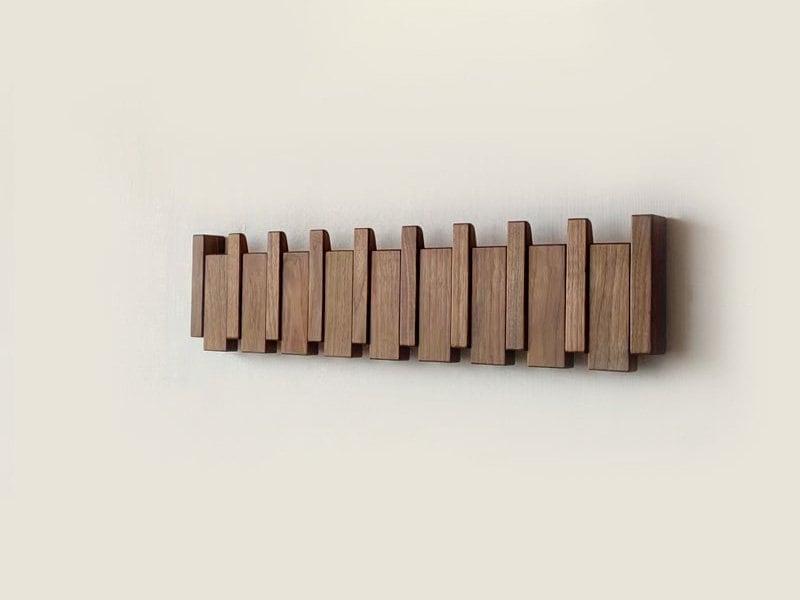 Modern multi-tone wooden coat rack for entryways, features stylish folding wall hooks.