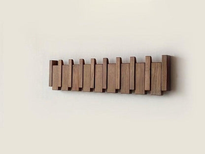 Modern multi-tone wooden coat rack for entryways, features stylish folding wall hooks.