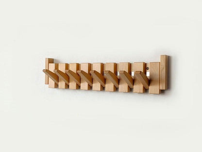 Efficient entryway organizer: handmade wooden coat rack with space-saving folding hooks.