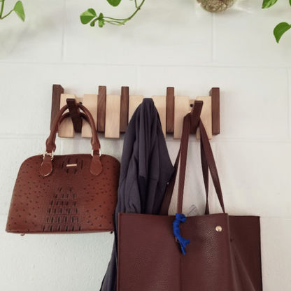 Wall-mounted handmade coat rack, multi-tone wood, with hideaway folding hooks for a neat entryway.