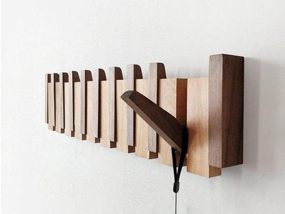 Unique handmade wooden coat rack featuring a multi-tone finish & practical folding wall hooks for entryways.
