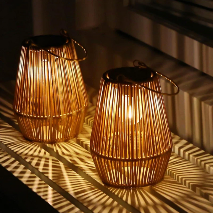 Beautiful handwoven solar lantern creating warm LED light on a garden path. Outdoor patio decor.