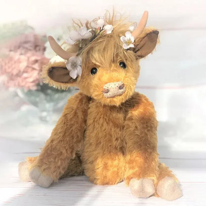 Cute handmade Highland Cow plush toy, a soft stuffed animal adorned with vibrant flowers. Ideal animal decor gift.
