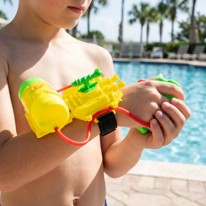 Child playing with a hands-free wrist water gun, enjoying summer fun at the beach or backyard.