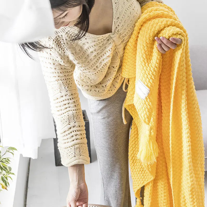Versatile knitted wool throw blanket with tassels, suitable for bed, sofa, or decorative accent.