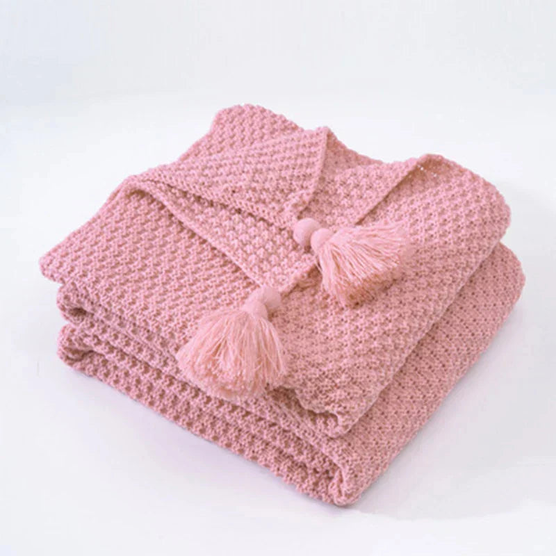 Cozy knitted wool bed blanket with tassels, perfect for a warm night's sleep.