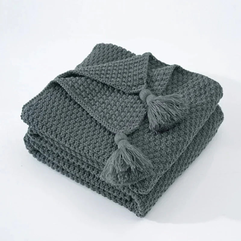 Ultra-soft knitted wool throw blanket with tassels, providing ultimate warmth & comfort.