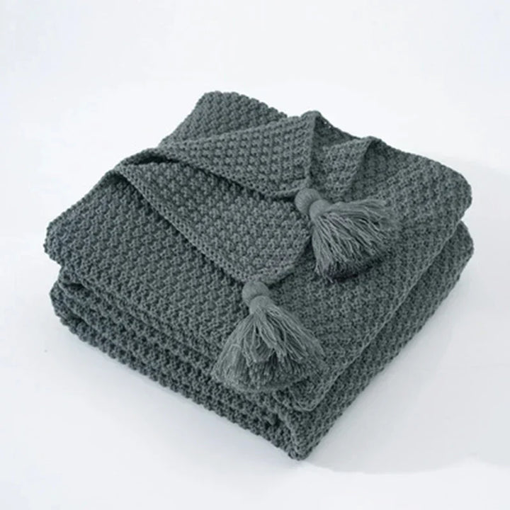 Ultra-soft knitted wool throw blanket with tassels, providing ultimate warmth & comfort.