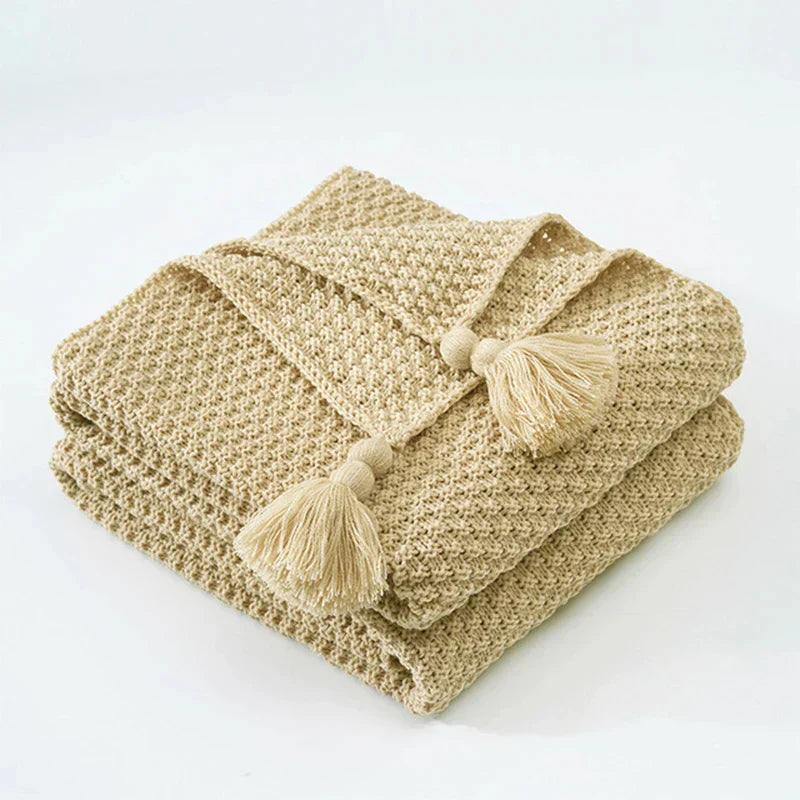 Luxurious knitted wool blanket with tassels, a perfect housewarming gift for cozy homes.