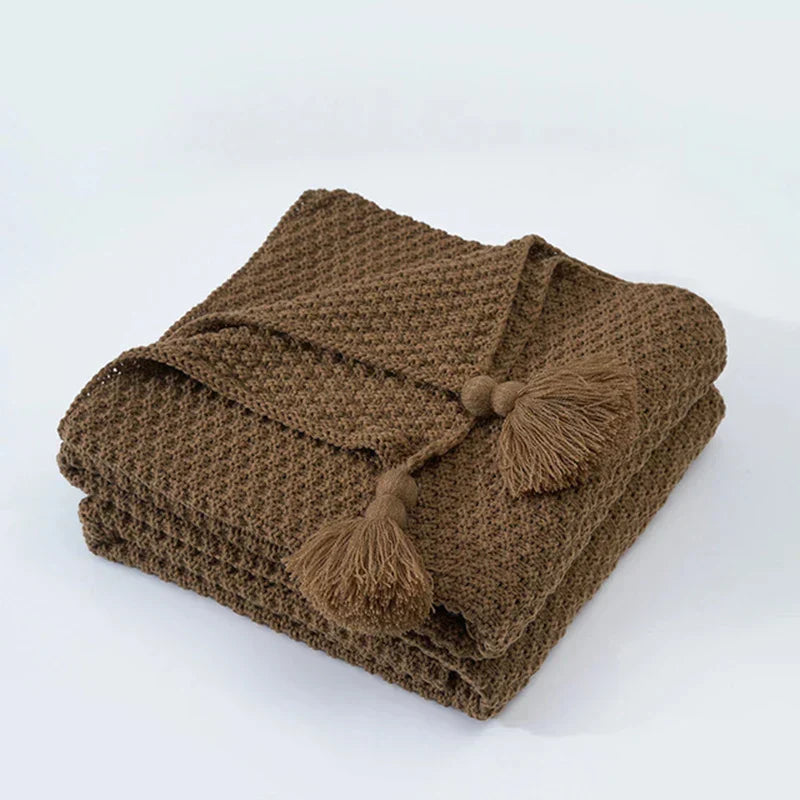 Scandinavian knitted wool throw, minimalist design with charming tassels for warmth.