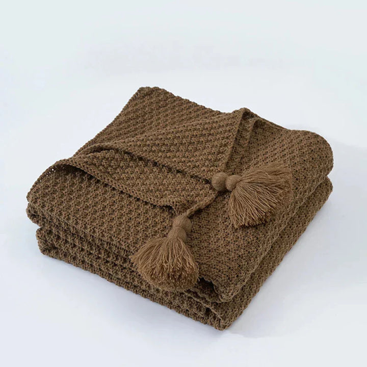 Scandinavian knitted wool throw, minimalist design with charming tassels for warmth.
