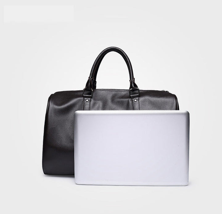Lightweight black faux leather duffel bag. Spacious carry-on for travel, gym, or overnight essentials.