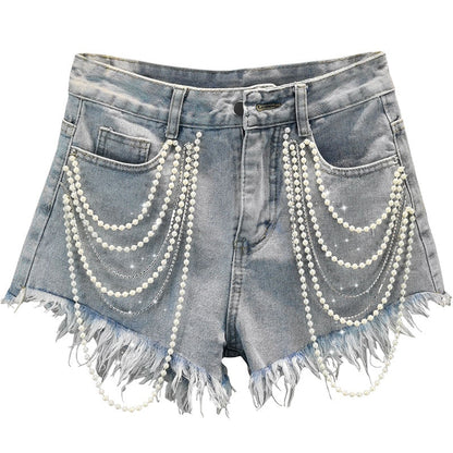 Light blue women's denim shorts with elegant pearl and playful tassel details, perfect for chic summer casual wear.