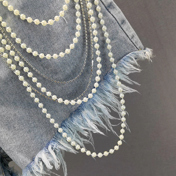 Designer-inspired women's pearl tassel denim shorts in light blue, offering a trendy and casual summer look.