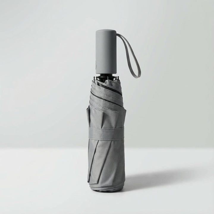 Light green windproof mini travel umbrella, shown folded for compact storage.