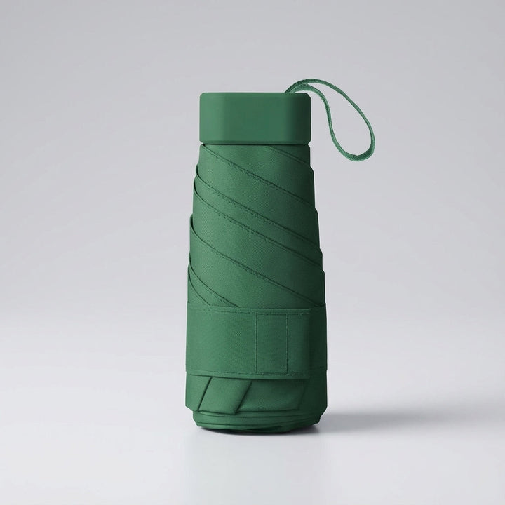 Compact light green mini travel umbrella, windproof & portable for easy carrying.