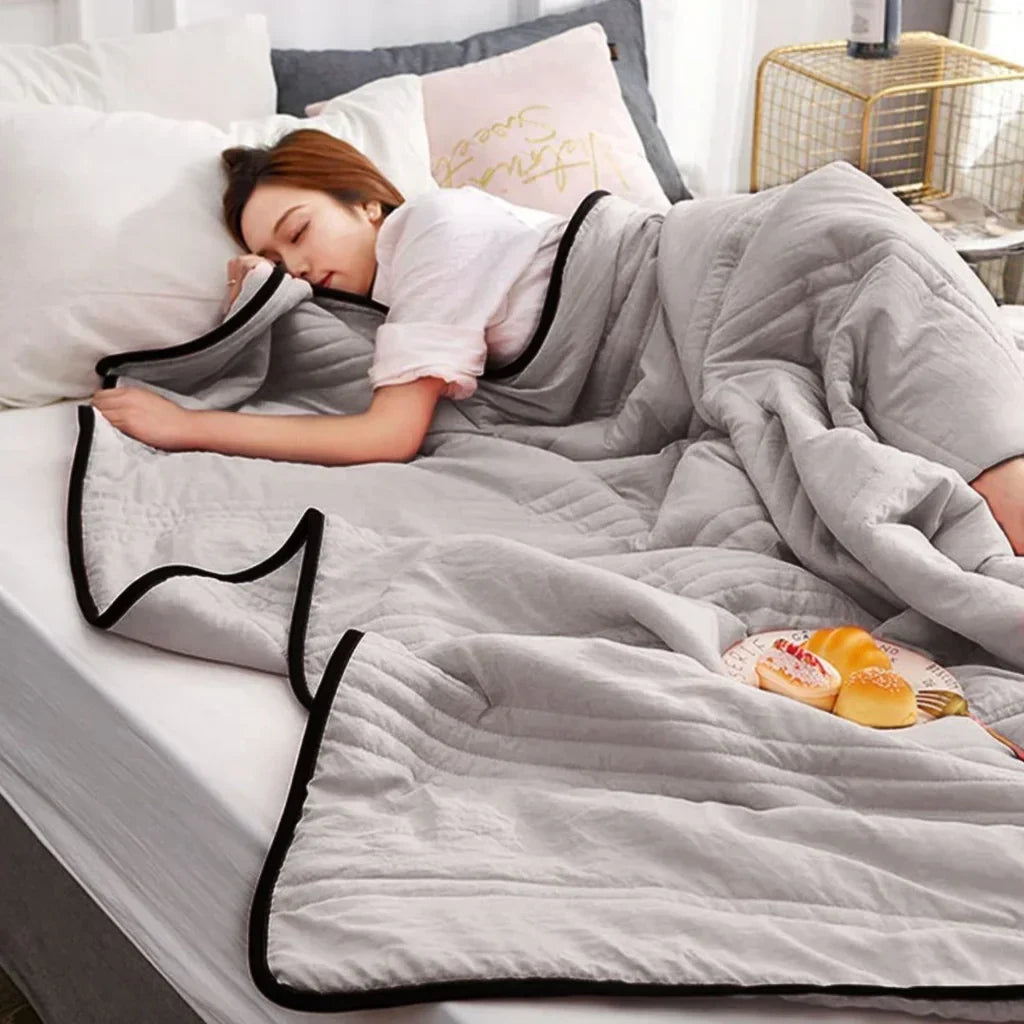 Lightweight, breathable pink cooling blanket made from bamboo & cotton blend, perfect for restful summer sleep.