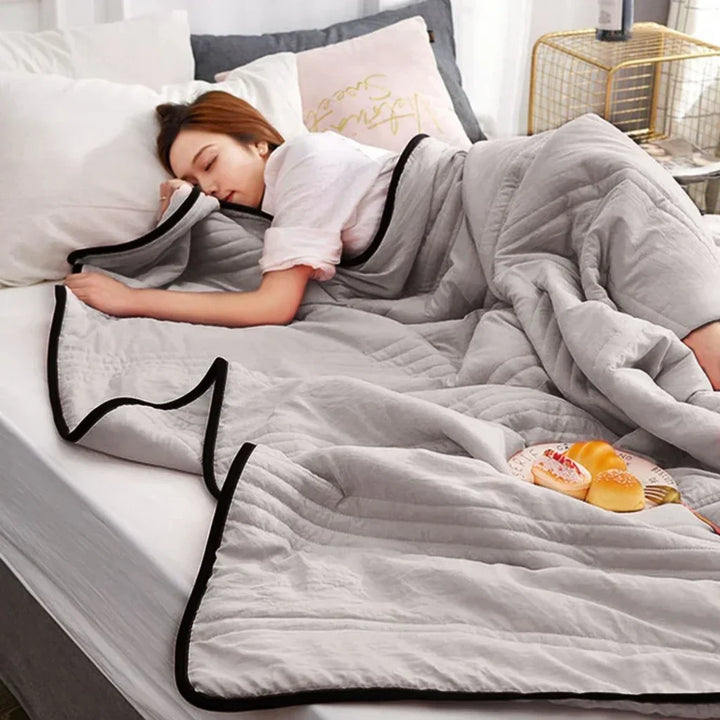 Lightweight, breathable pink cooling blanket made from bamboo & cotton blend, perfect for restful summer sleep.