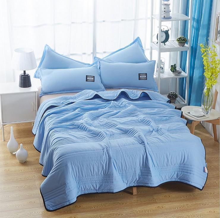 Unisex blue cooling blanket: breathable, lightweight bamboo & cotton for comfortable sleep on hot summer nights.
