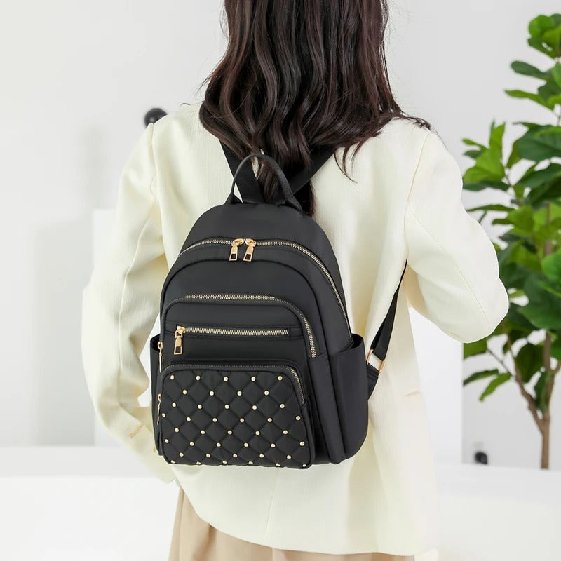 Lightweight water-resistant nylon commuter backpack for women, keeps essentials dry & secure.