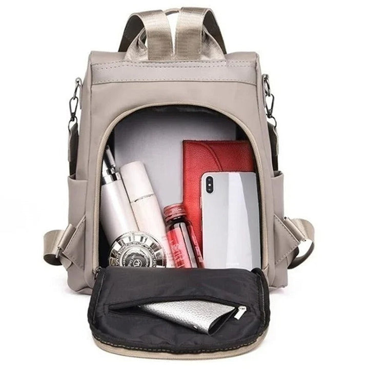 Stylish woman with a black water-resistant nylon crossbody bag. This lightweight multi-way backpack is versatile.