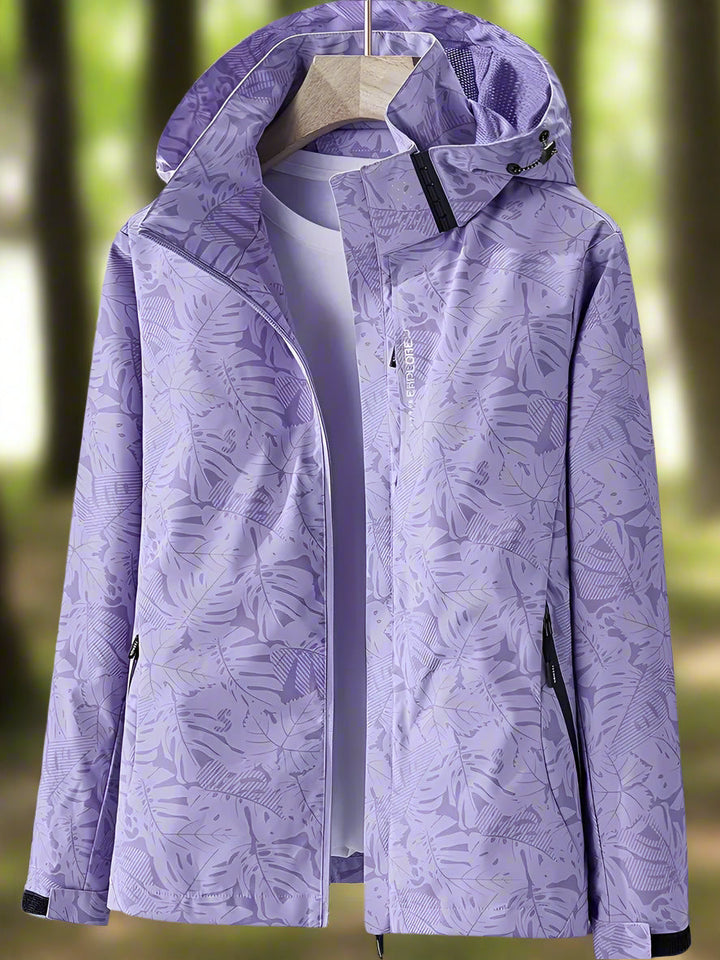 Detailed close-up of a women's lightweight waterproof jacket, showcasing its unique leaf print pattern.