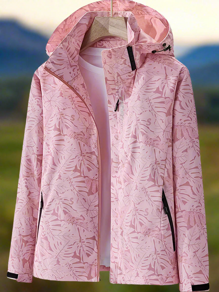 Woman wearing a stylish lightweight waterproof summer jacket with a vibrant leaf print outdoors.
