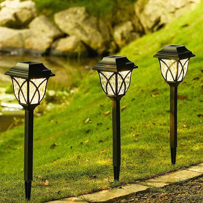 Elegant LunaGlow solar garden lights with a modern design, casting a warm glow on a garden path at night.