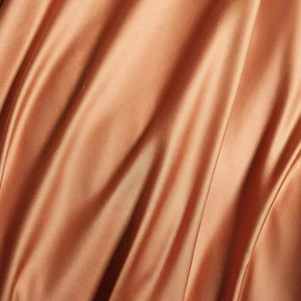 Hand touching the soft, smooth satin cotton bedding, emphasizing the luxurious feel and comfort for year-round use.