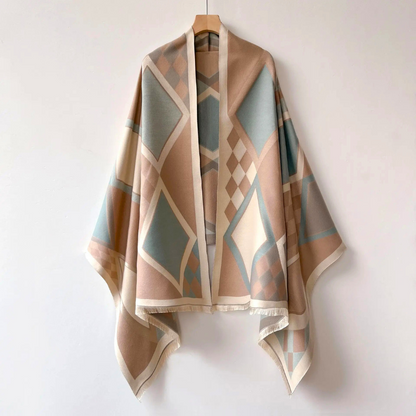 Elegant woman wearing a stylish cashmere winter wrap, draped beautifully over an outfit.